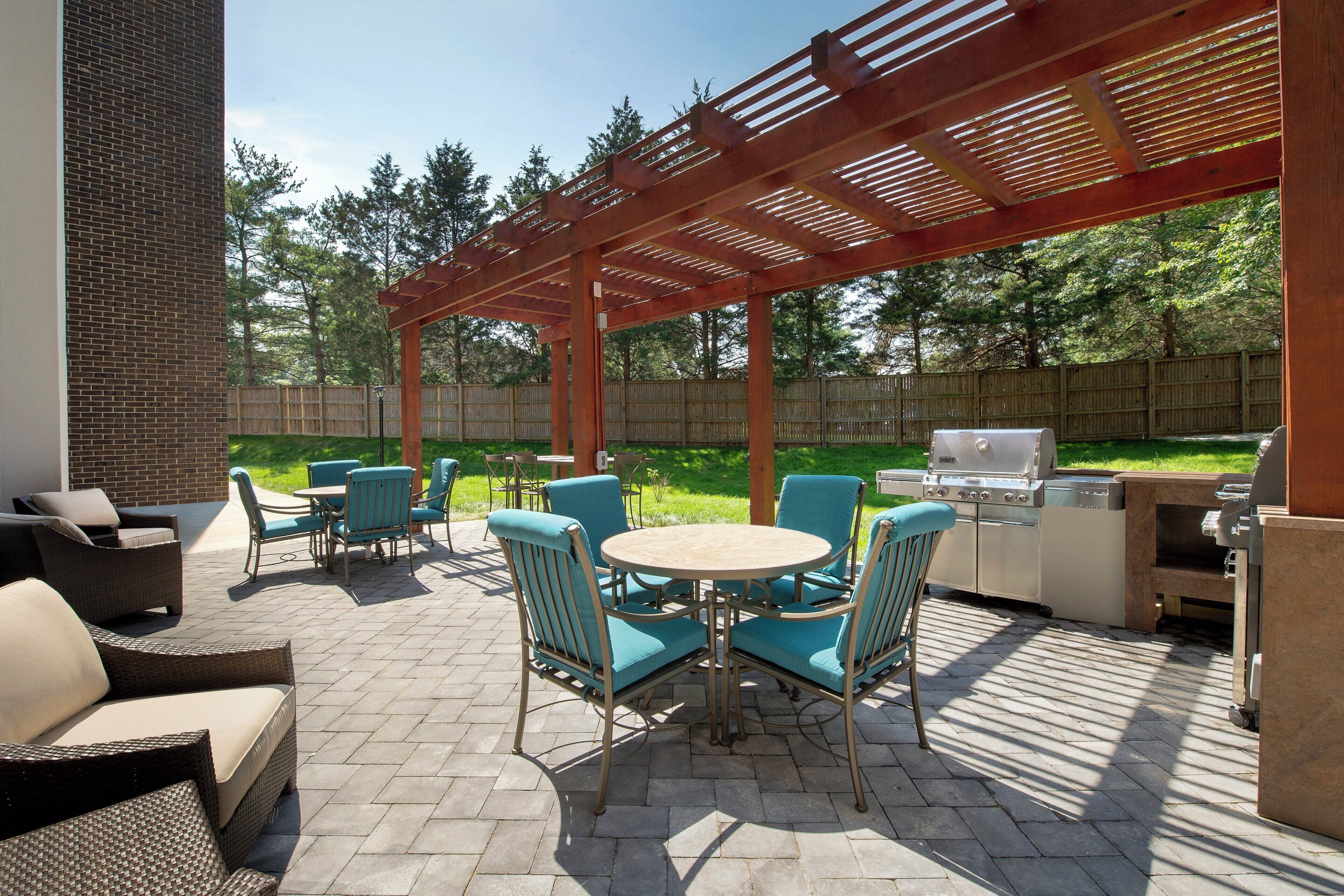 Une terrasse extérieure dotée d’une pergola, d’un espace salon et d’un barbecue encastré.
