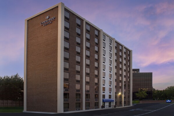 Un hôtel à plusieurs étages, doté d’une façade en briques et d’une enseigne indiquant « Candlewood Suites ».