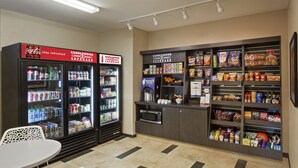 A self-service kiosk with refrigerated beverage dispensers, a microwave, and a variety of snacks and condiments. - Candlewood Suites Alexandria West by IHG (Alexandria)