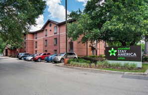A brick building with a sign for Extended Stay America Suites. There are several cars parked in front. - Extended Stay America Suites Tallahassee Killearn (Tallahassee)
