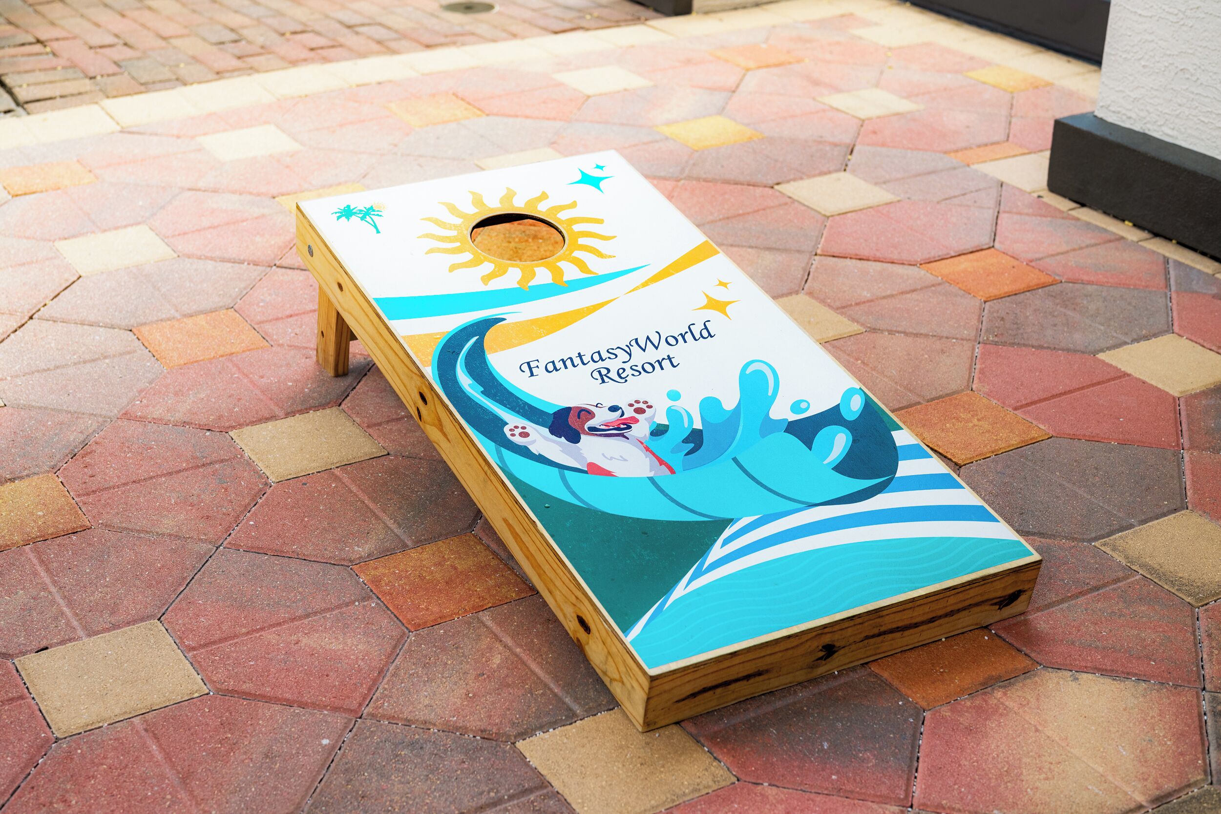 Une planche en bois ornée d’un motif coloré et portant l’inscription « FantasyWorld Resort ».