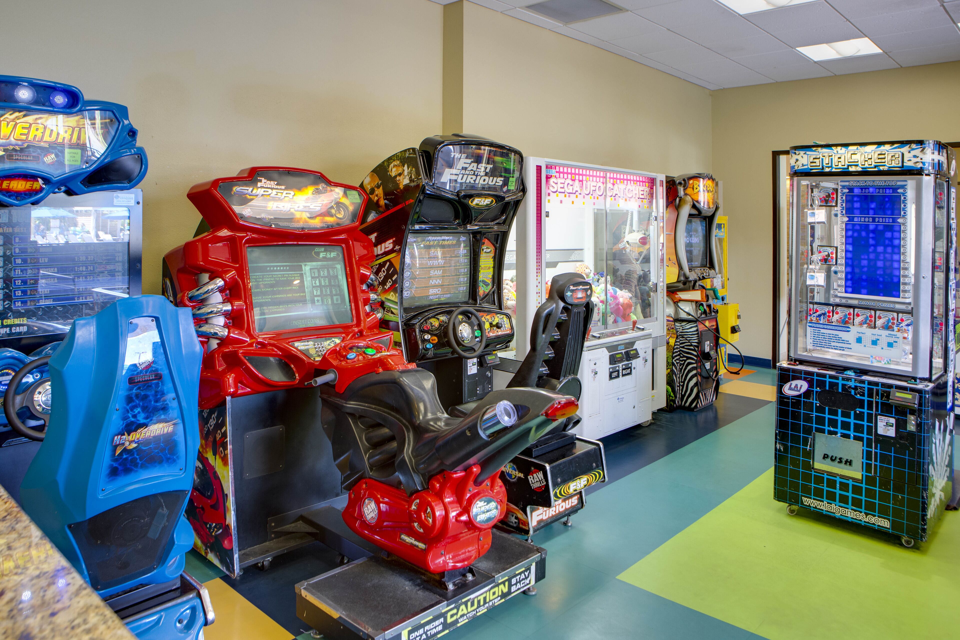 A row of arcade machines in a room with a green floor.