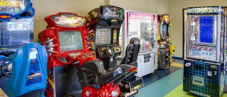 A row of arcade machines in a room with a green floor.