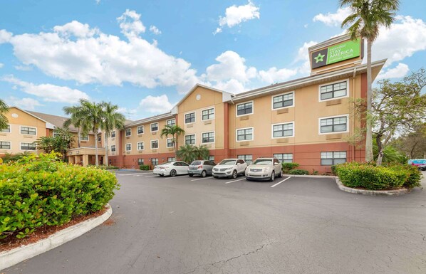 Un hotel con estacionamiento, varios pisos y un cartel que indica que es una propiedad de Extended Stay America.