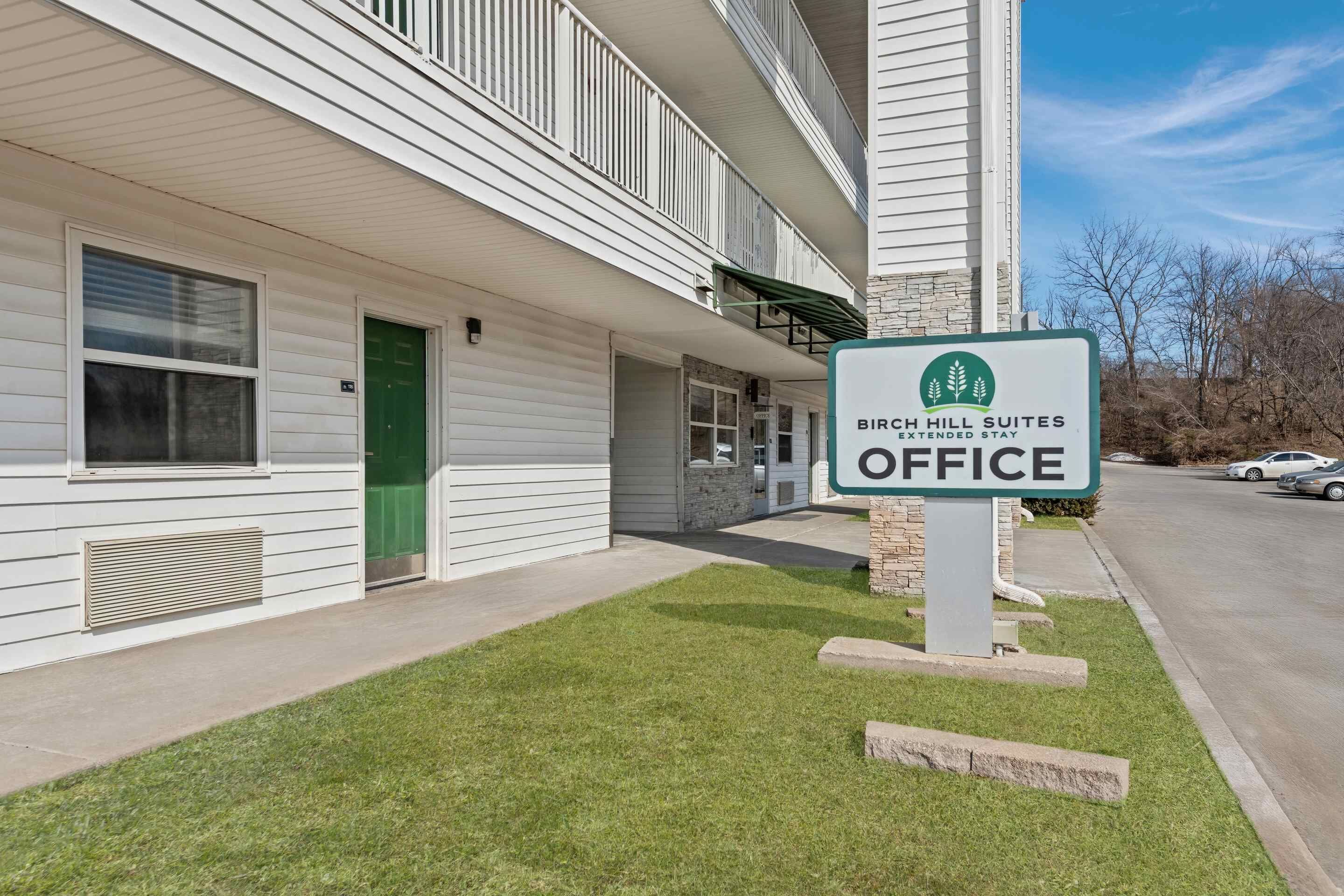 Un edificio con un cartel que dice 'Bird Hill Suites Office'.