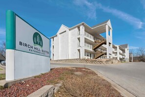 Ein mehrstöckiges Hotel mit einem Schild für Birch Hill Suites.
