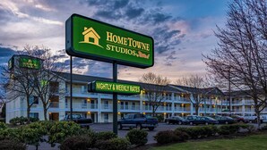 A hotel sign for Home Towne Studios by RedRoof with a parking sign indicating nightly and weekly rates. - HomeTowne Studios By Red Roof Eugene - Springfield (Springfield)