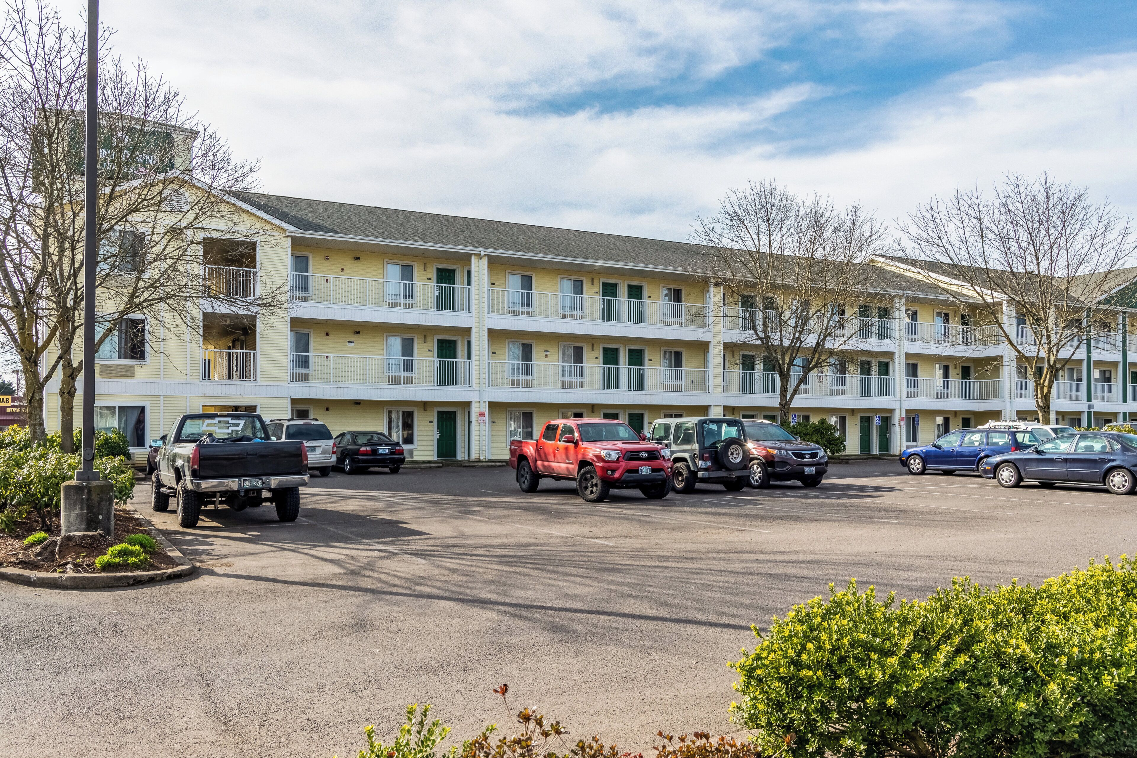A multi-story motel with a parking lot.