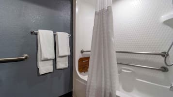 Un baño con una bañera, una cortina de ducha y un perchero con dos toallas.