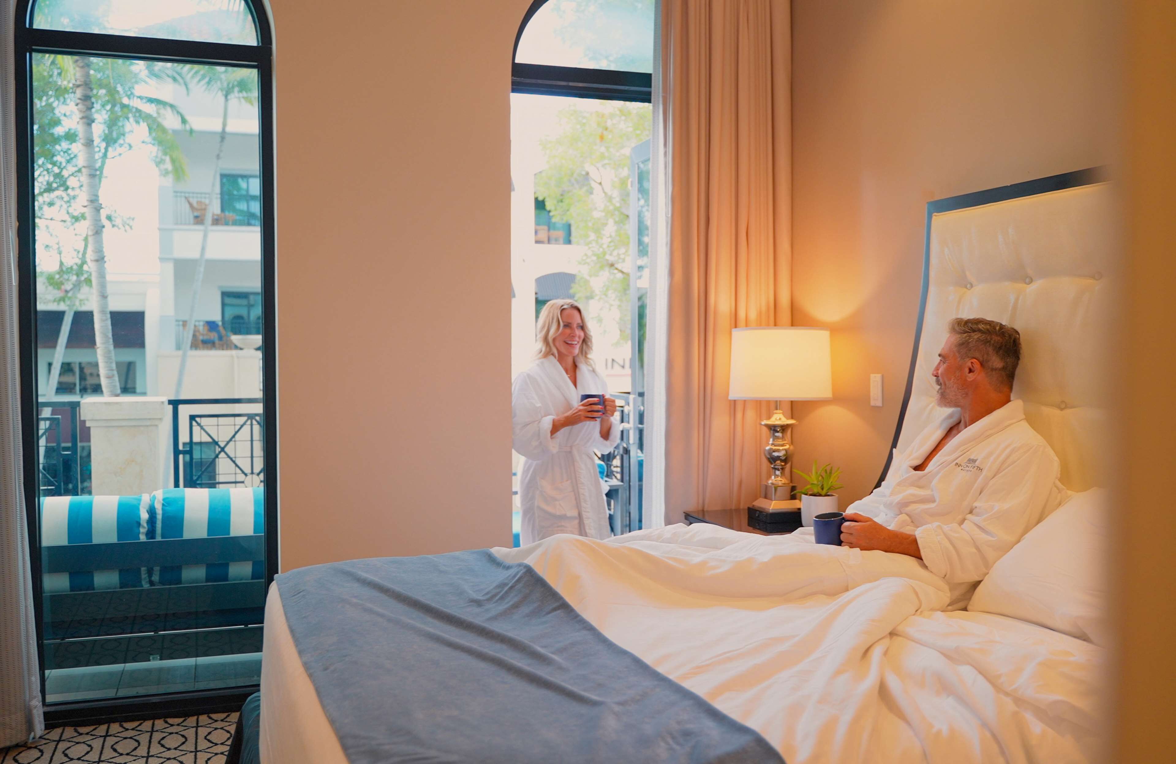 Une chambre d’hôtel avec un lit, une lampe de chevet et une vue sur le balcon extérieur.