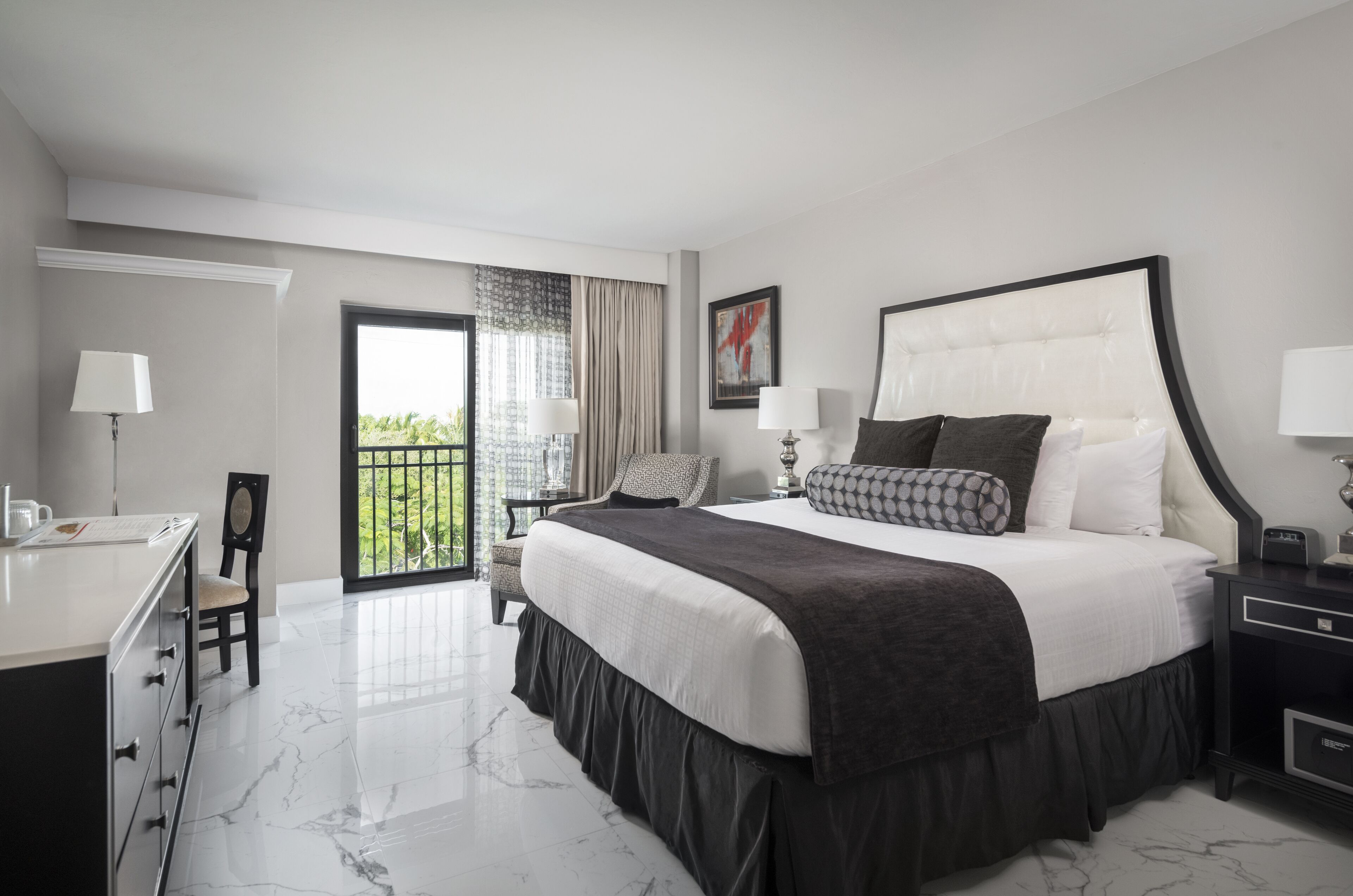 Een moderne hotelkamer met een groot bed, een bureau en een stoel.