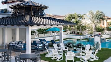 Alberca al aire libre, sombrillas en la alberca y camastros