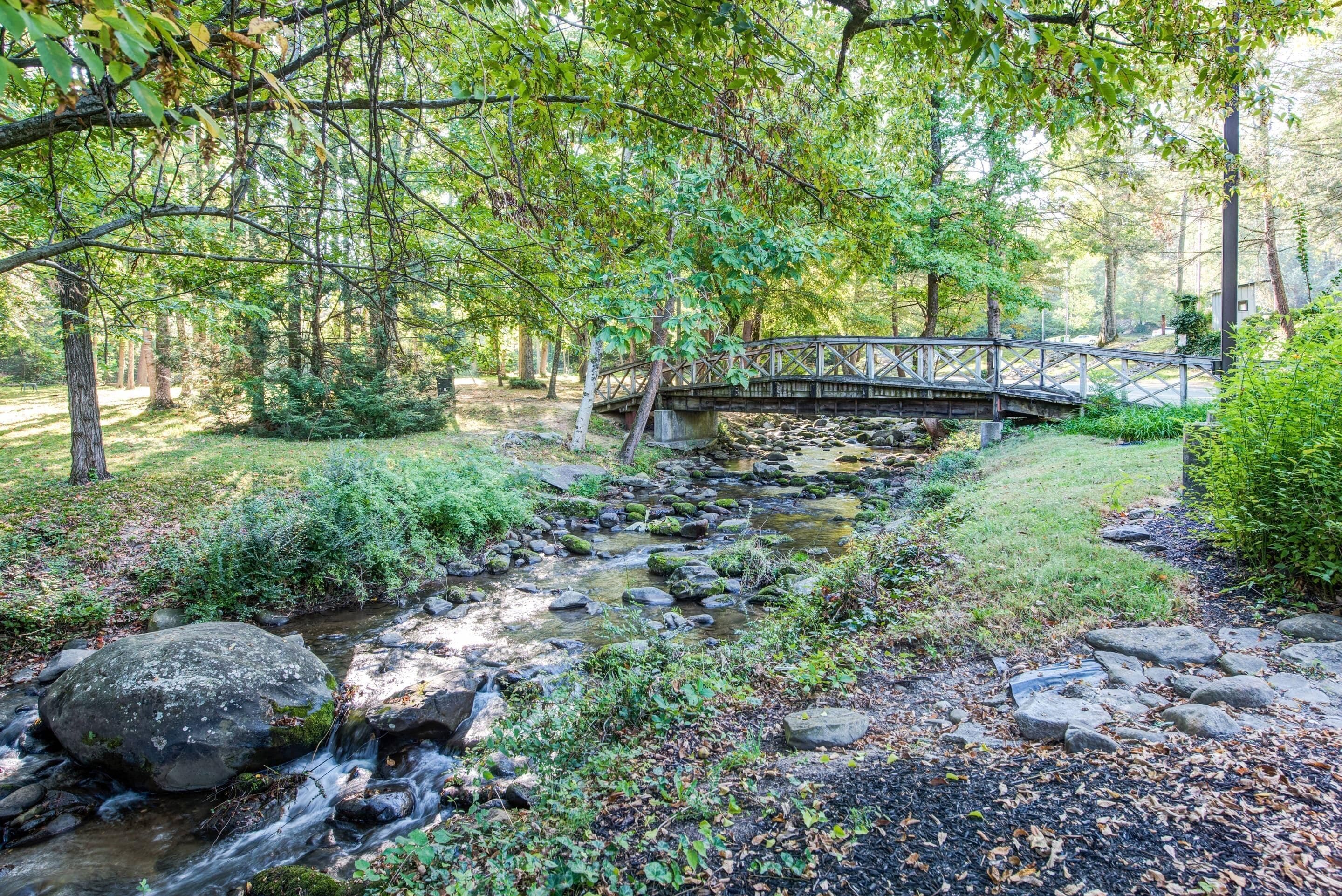 A wooden bridge over a stream in a wooded area.