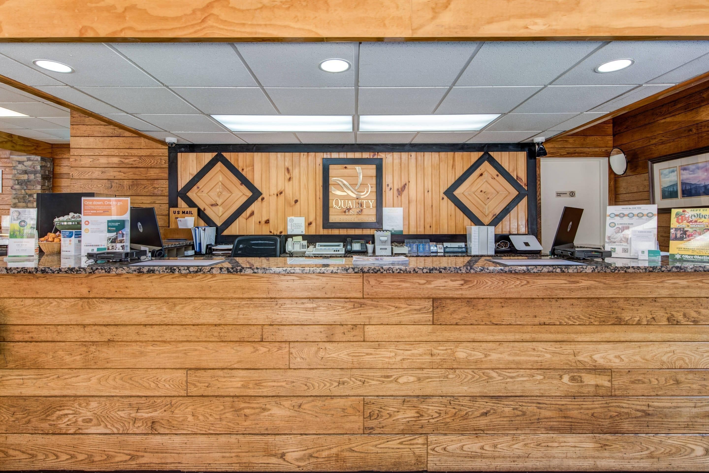 Un mostrador de recepción con detalles de madera, un letrero que dice 'Quality' y un buzón de correo de Estados Unidos.