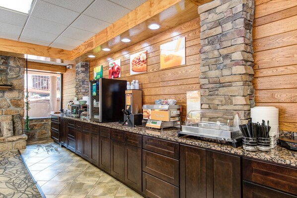 A breakfast bar with stone walls, wooden ceiling, and a view of the outside.
