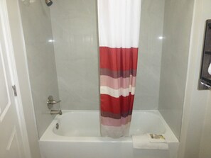 Ein Badezimmer mit Duschvorhang, Badewanne und Handtuchhalter.
