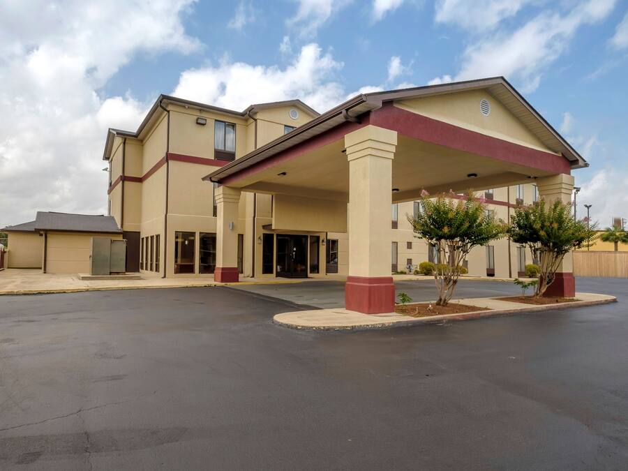 Un hotel de varios pisos con entrada cubierta y estacionamiento.
