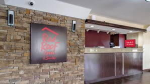 A reception area with a stone wall, a Red Roof Inn sign, and a digital display stating 'Free Wi-Fi All Rooms'. - Red Roof Inn & Suites Mobile SW – I-10 (Mobile)