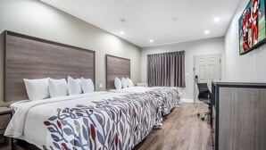 A hotel room with a large bed, a desk, and a television on the wall. - Red Roof Inn & Suites Mobile SW – I-10 (Mobile)