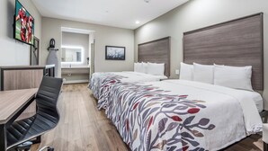 Une chambre d’hôtel avec un lit, un bureau, une chaise, un miroir et un tableau au mur.