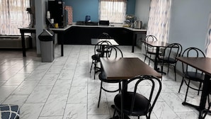Un restaurante con mostrador, sillas y piso de baldosas.