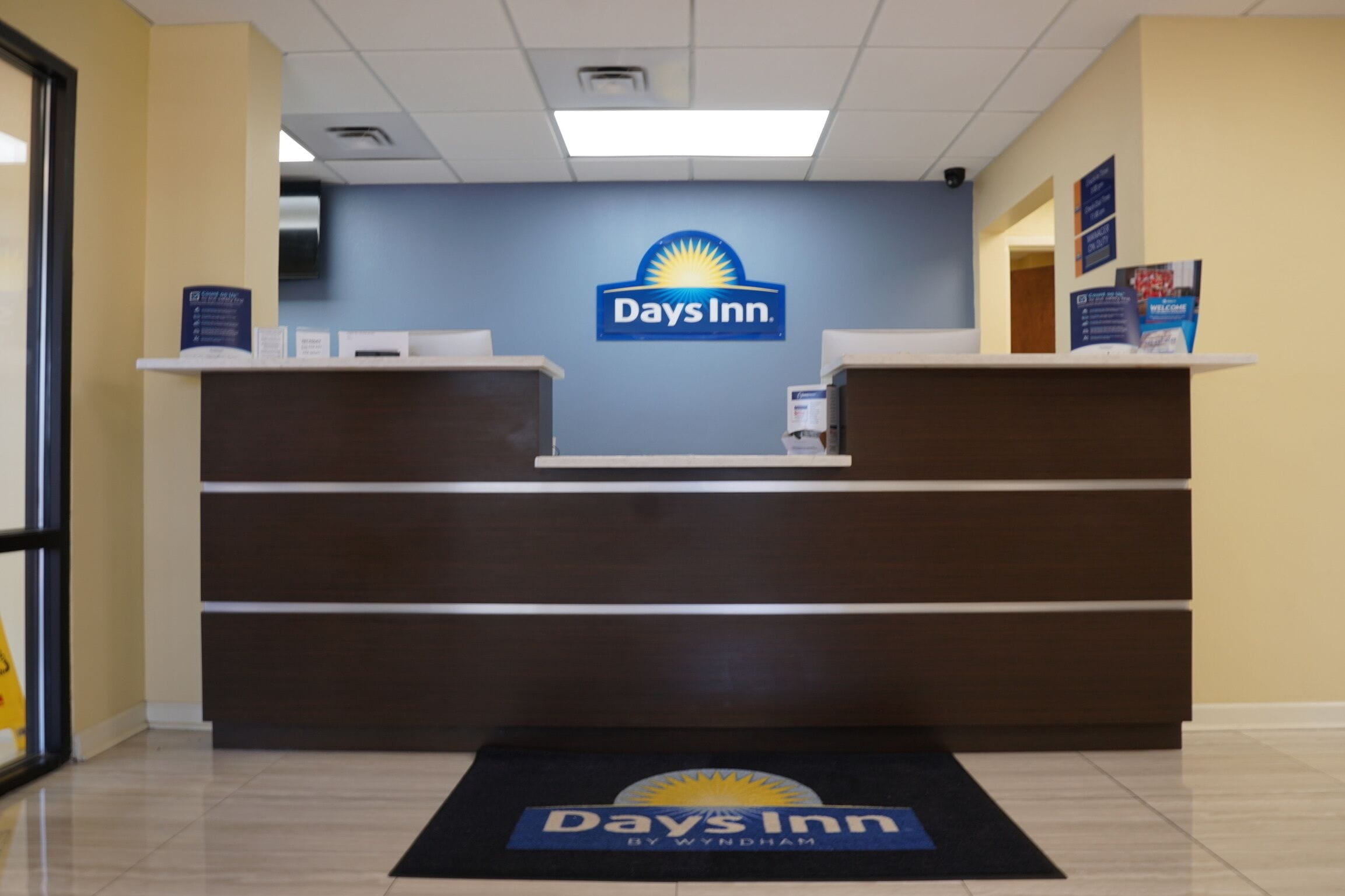 Balcão de atendimento no Days Inn, com parede azul e um logotipo.