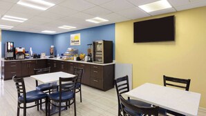 A breakfast area with a counter, seating, and a TV mounted on the wall. - Days Inn by Wyndham Oak Grove/Ft. Campbell (Oak Grove)