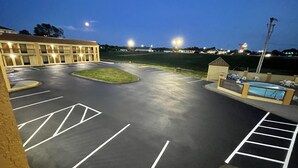 A parking lot with marked spaces and a building in the background. - Days Inn by Wyndham Oak Grove/Ft. Campbell (Oak Grove)