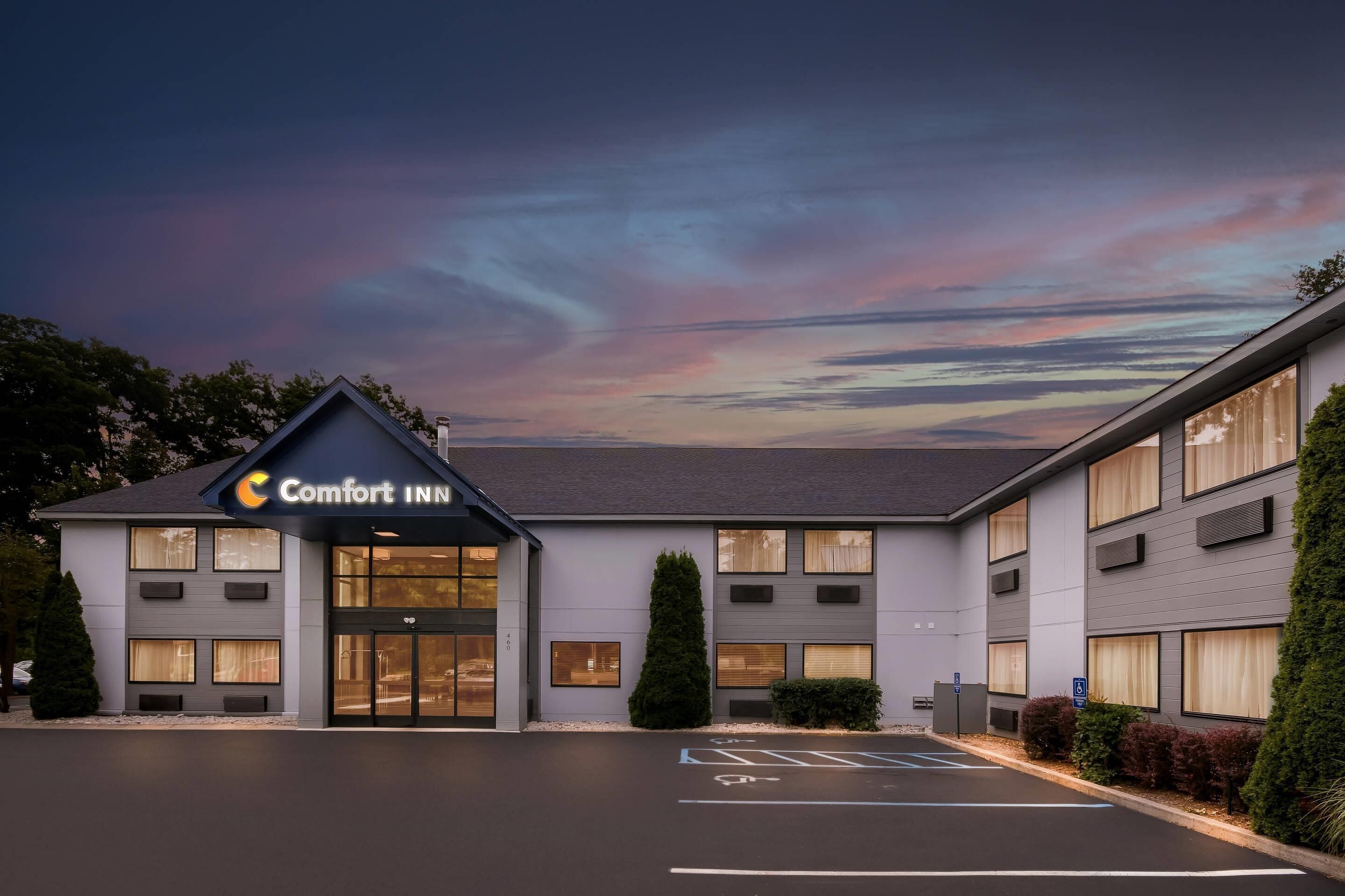 Modernilla designilla varustettu Comfort Inn -hotelli, jossa on pysäköintialue ja selkeä taivas pilvineen.