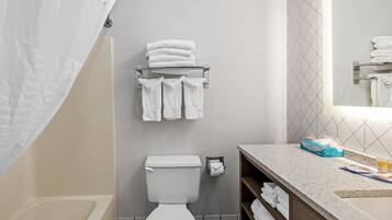 A modern bathroom with a toilet, towel rack, and a sink area.