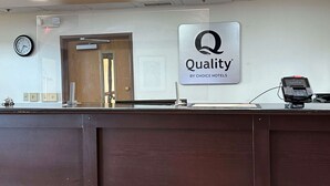 Un mostrador de recepción de hotel con un cartel que dice "Quality by Choice Hotels".