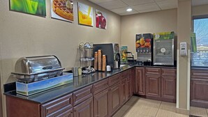 Una barra de desayuno con tostadora, cafetera y dispensador de zumo.