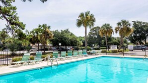 A rectangular swimming pool with a tiled edge, surrounded by a metal fence. - Days Inn by Wyndham Little River (Little River)