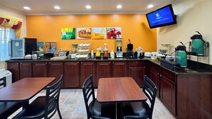 A breakfast bar with seating, a coffee machine, and a TV screen displaying a message. - Quality Inn Ukiah (Ukiah)