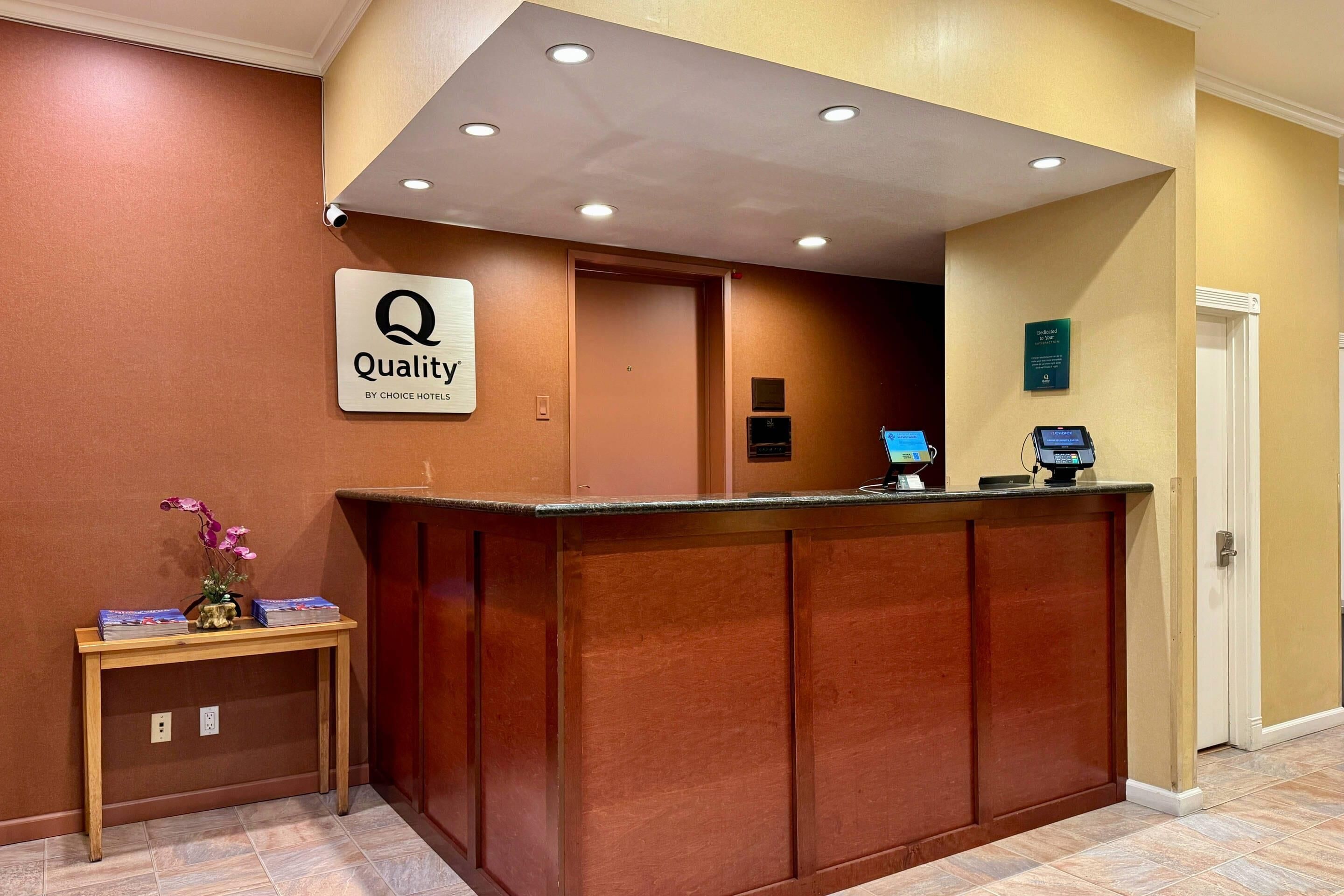 Un mostrador de recepción de hotel con un letrero que dice "Quality by Choice Hotels".
