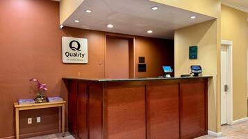 Un mostrador de recepción de hotel con un letrero que dice "Quality by Choice Hotels".