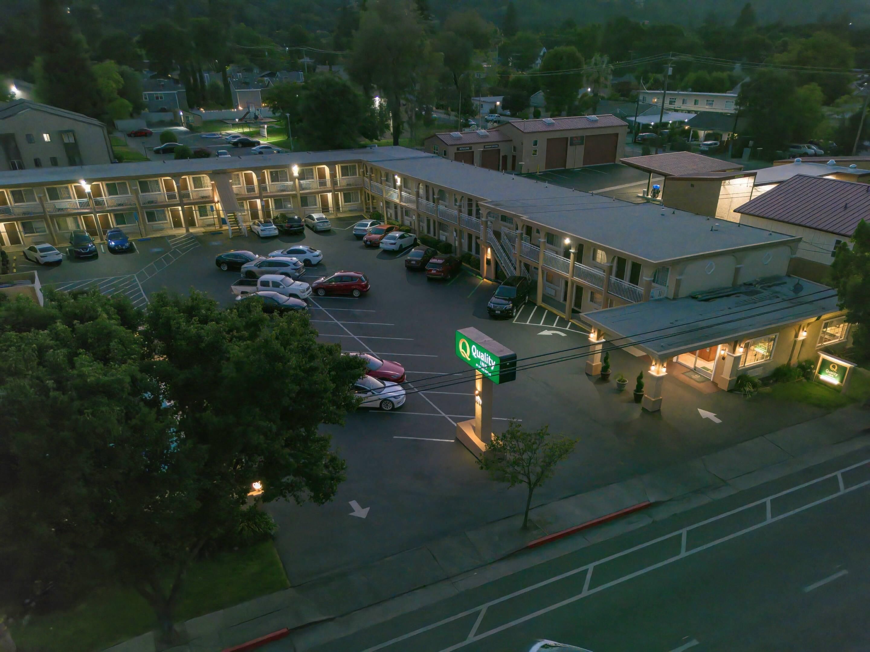 A motel with multiple parking spaces and a sign indicating 'Quality Inn'.