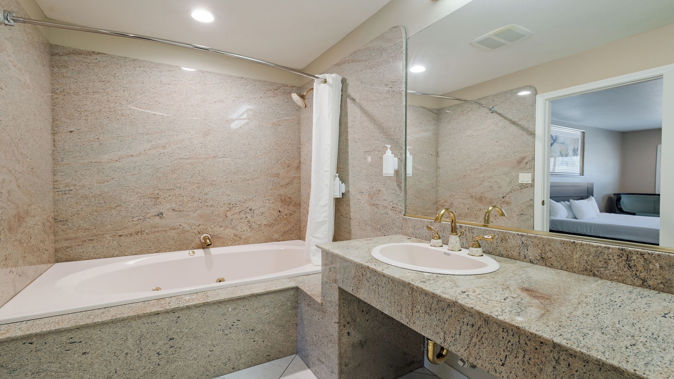 Un baño con bañera, dos lavamanos, ducha y un espejo grande.