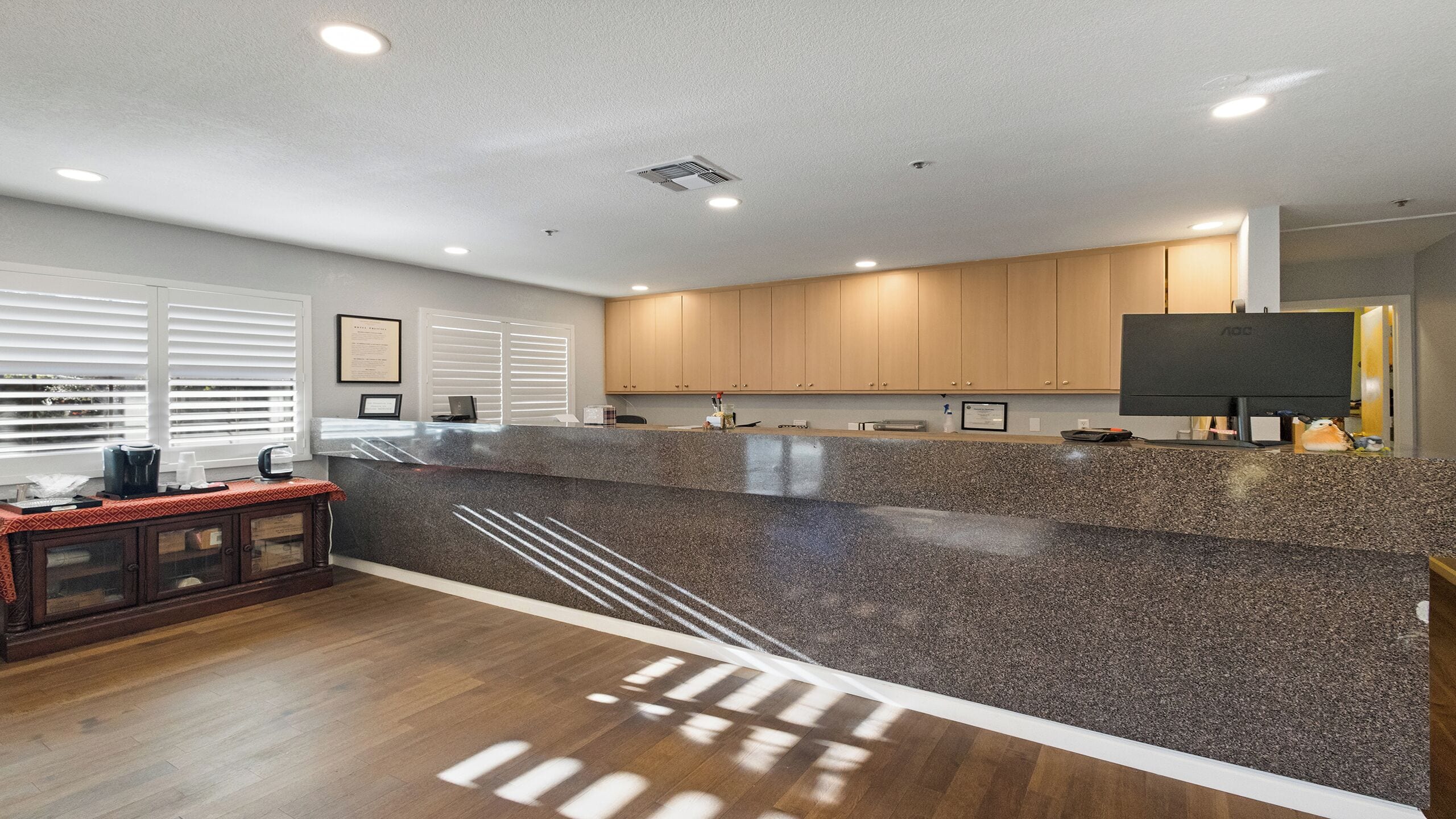 A modern kitchen with granite countertops, wooden cabinets, and a built-in stove.