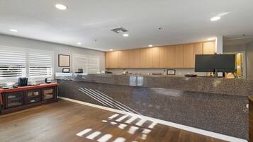 A modern kitchen with granite countertops, wooden cabinets, and a built-in stove.
