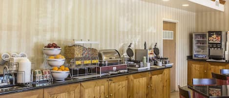 A breakfast bar with various food items and a coffee machine.