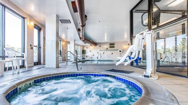A hot tub area with a tiled floor, a large window, and a view of the outside. - Comfort Suites Summit County (Dillon)