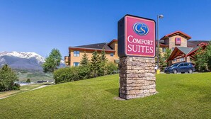 A sign for Comfort Suites hotel with a mountain backdrop. - Comfort Suites Summit County (Dillon)