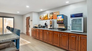 A modern kitchen with wooden cabinets, a granite countertop, and a coffee machine. - Comfort Inn Livingston (Livingston)