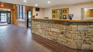 A reception area with a stone counter, a clock, and a payment terminal. - Comfort Suites Boone - University Area (Boone)
