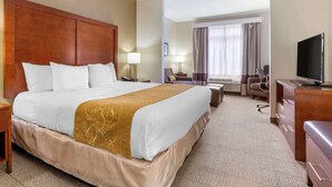 A hotel room with a large bed, a desk, a television, and a window with curtains. - Comfort Suites Boone - University Area (Boone)