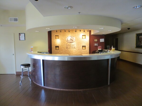 Ein Hotelrezeptionstresen mit einem Schild, auf dem 'Comfort Suites' steht.