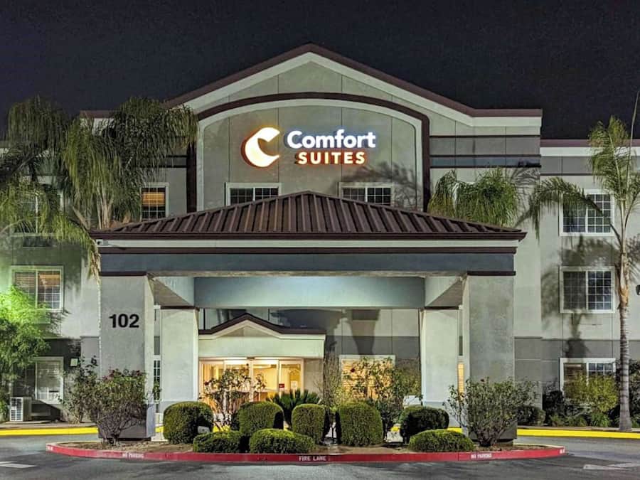 Un hotel Comfort Suites con fachada moderna, entrada cubierta y número 102.