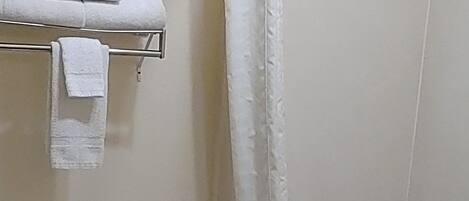 Un baño con inodoro, bañera y cortina de ducha.