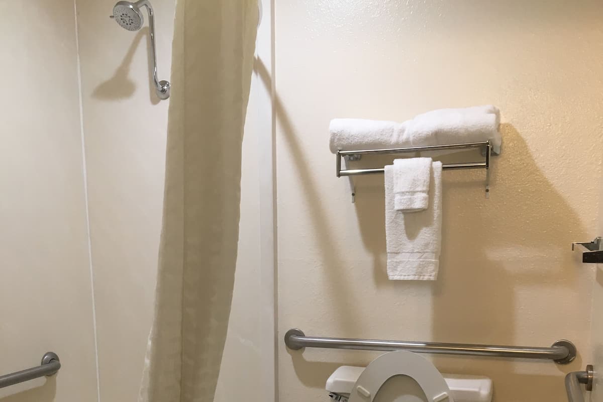 A bathroom with a bathtub, toilet, and a shower curtain.